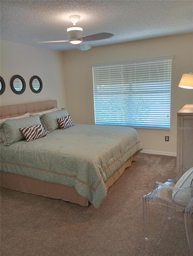 carpeted bedroom featuring a textured ceiling, ceiling fan, and baseboards