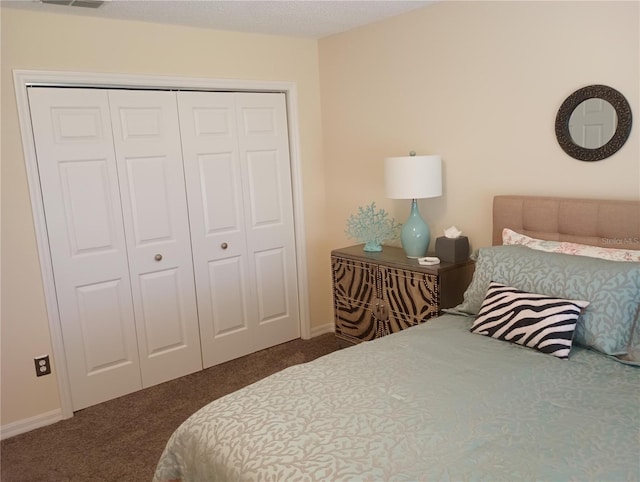 carpeted bedroom featuring baseboards, visible vents, and a closet