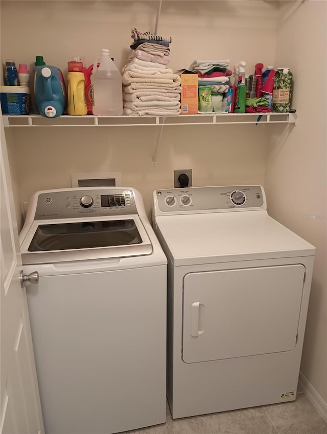 laundry room featuring laundry area, light tile patterned flooring, and washer and clothes dryer