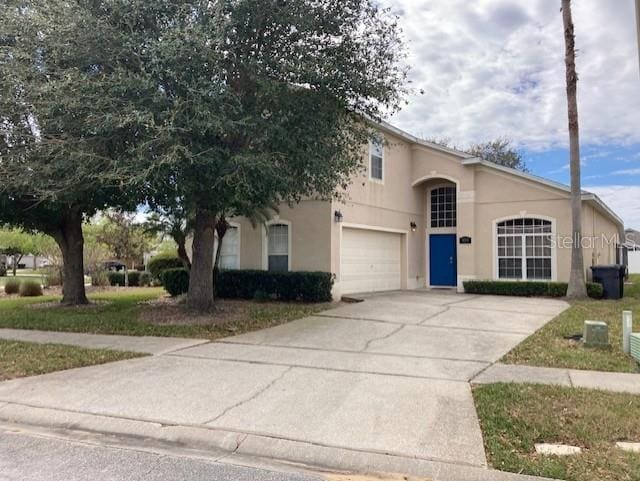 view of front of home featuring driveway, an attached garage, and stucco siding