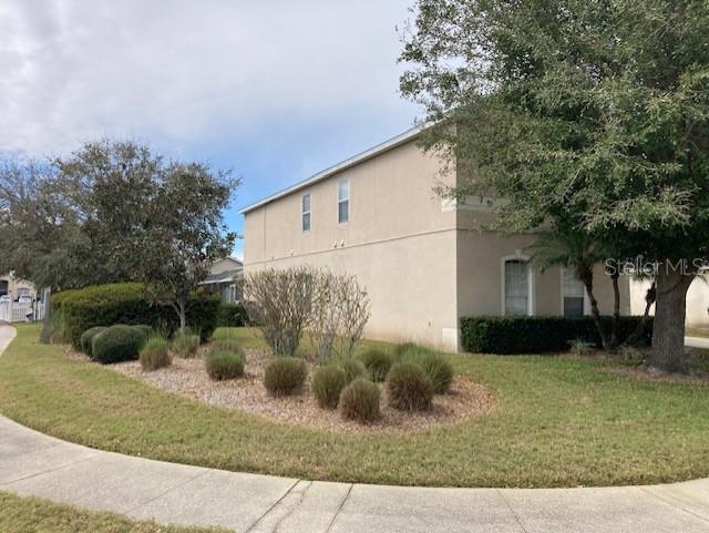 954 Lockbreeze Dr, Davenport, FL 33897 - view of side of property featuring stucco siding and a yard