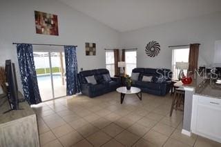 954 Lockbreeze Dr, Davenport, FL 33897 - living area with healthy amount of natural light, light tile patterned flooring, and high vaulted ceiling