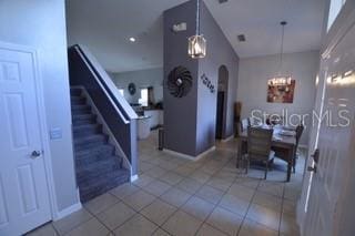 954 Lockbreeze Dr, Davenport, FL 33897 - dining area with a chandelier, stairway, tile patterned flooring, arched walkways, and lofted ceiling