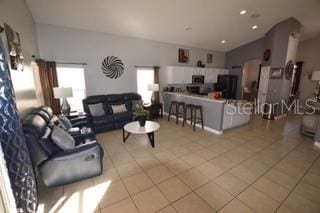 954 Lockbreeze Dr, Davenport, FL 33897 - living area with light tile patterned flooring and vaulted ceiling