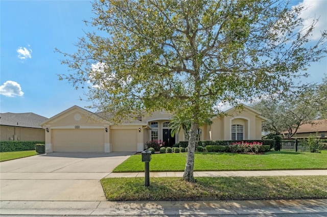 view of front of house with concrete driveway, stucco siding, an attached garage, and a front yard