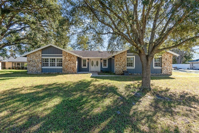 view of front of property with stone siding, board and batten siding, and a front yard