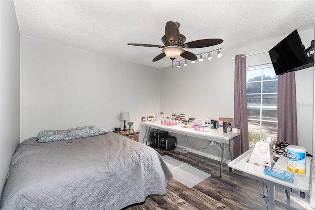 bedroom featuring a textured ceiling, a ceiling fan, and wood finished floors