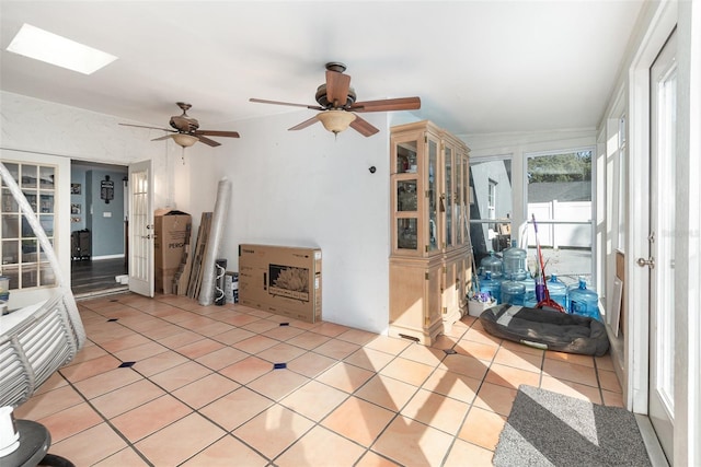 living area with a skylight and light tile patterned flooring