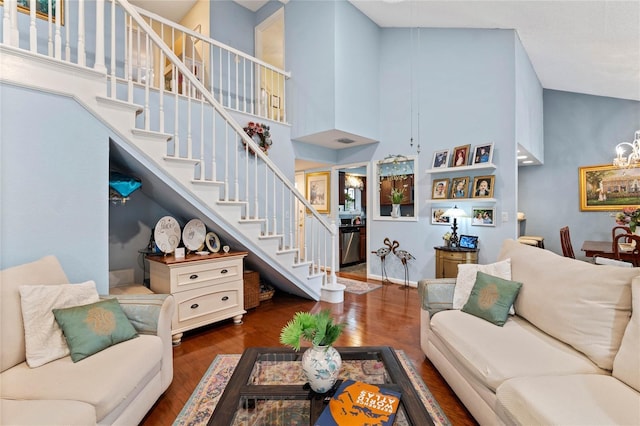 living area with stairs, a high ceiling, and wood finished floors