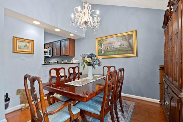 dining area with an inviting chandelier, baseboards, wood finished floors, and recessed lighting