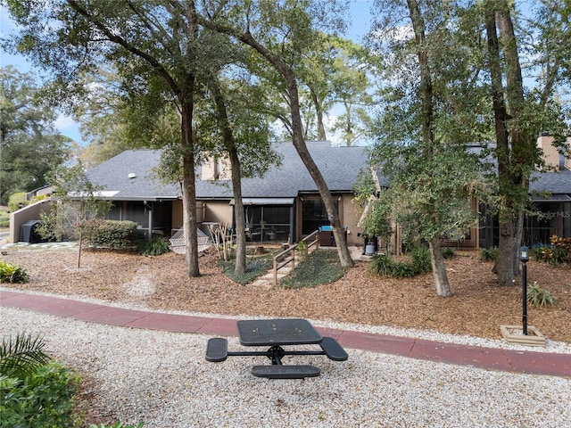 view of front of property featuring a shingled roof and a sunroom