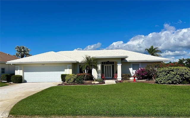 ranch-style home with a garage, a front yard, driveway, a tile roof, and stucco siding