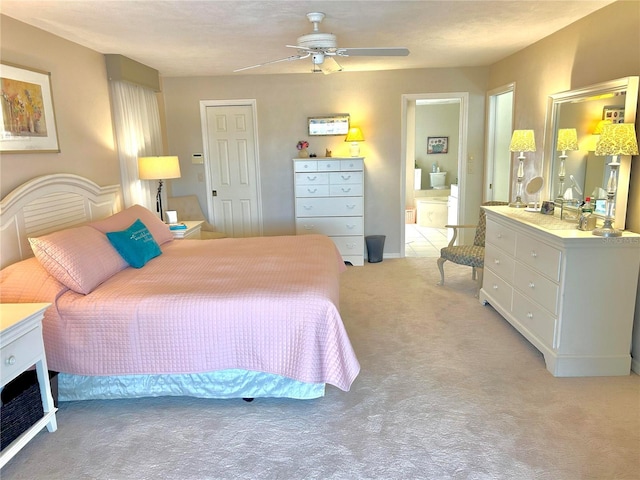 bedroom with light carpet, connected bathroom, and ceiling fan