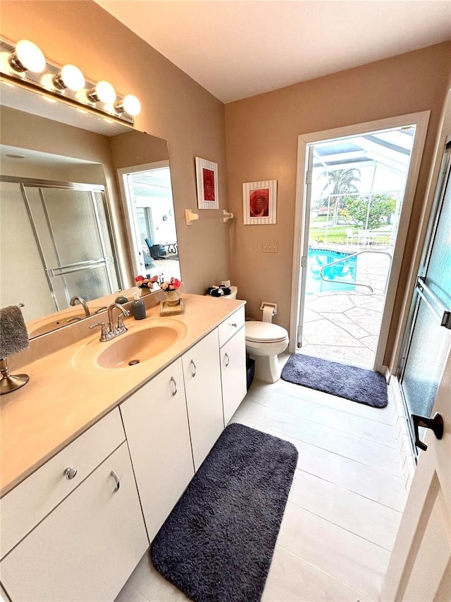 bathroom with a stall shower, vanity, tile patterned floors, and toilet