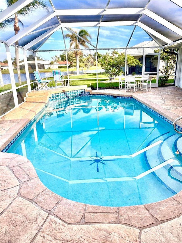 outdoor pool with a patio area and glass enclosure
