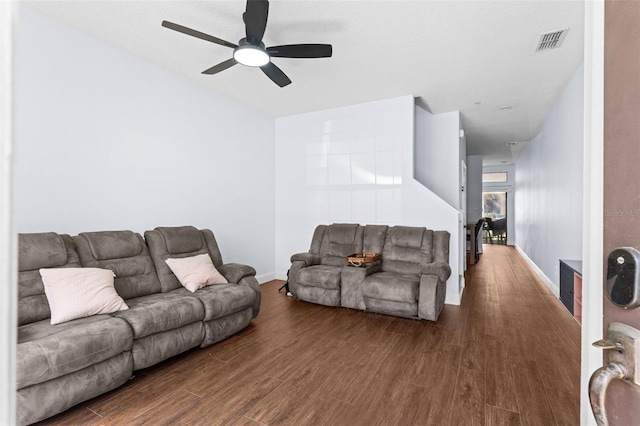 living area featuring visible vents, baseboards, and wood finished floors