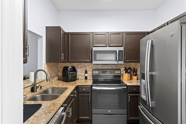 kitchen with a sink, dark brown cabinetry, decorative backsplash, and stainless steel appliances