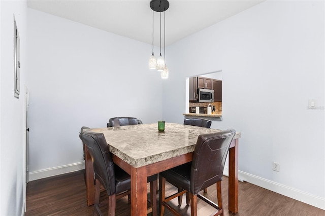 dining room with dark wood finished floors and baseboards