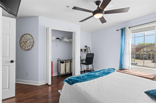 bedroom with a ceiling fan, a textured ceiling, wood finished floors, a closet, and baseboards