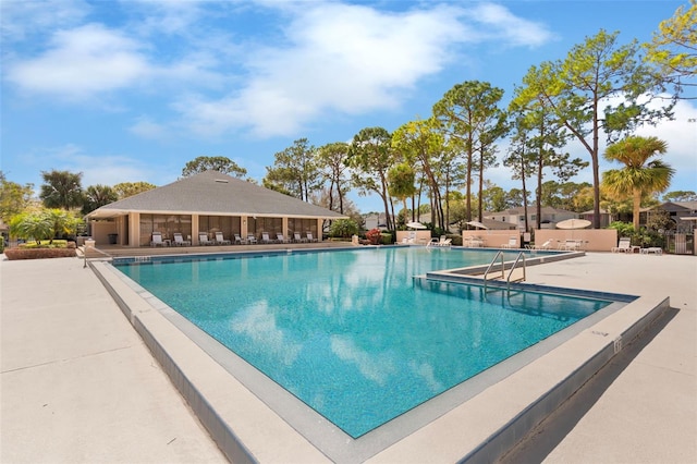 pool with a patio area and a water slide