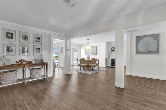 living area featuring dark wood-style floors, visible vents, crown molding, and baseboards