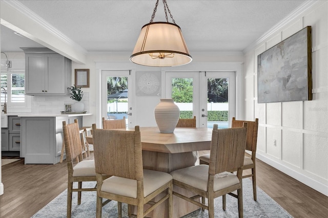 dining area with crown molding, plenty of natural light, and wood finished floors