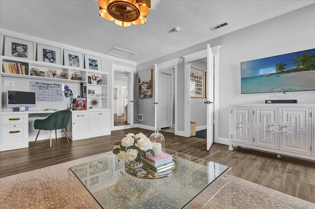 living room featuring crown molding, wood finished floors, visible vents, and built in desk