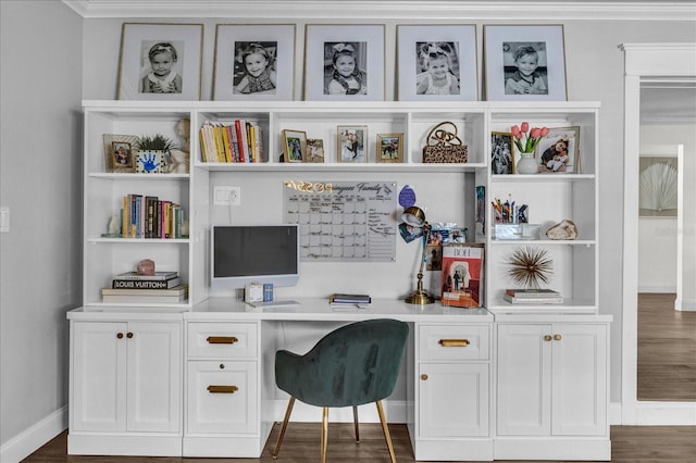 office area featuring baseboards, built in shelves, dark wood-type flooring, and built in study area