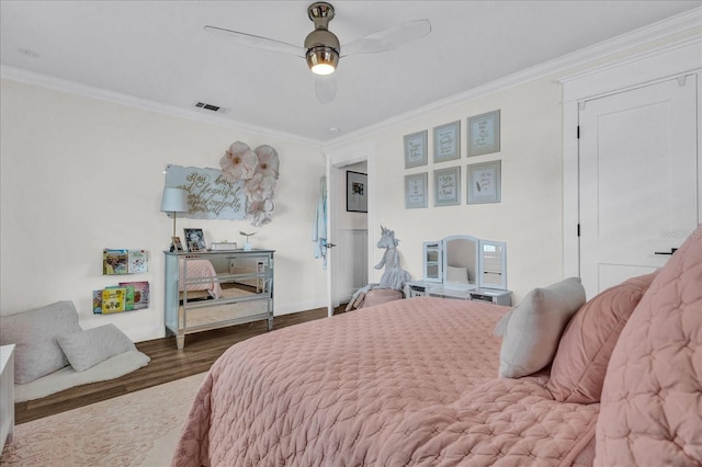 bedroom featuring visible vents, crown molding, baseboards, and wood finished floors