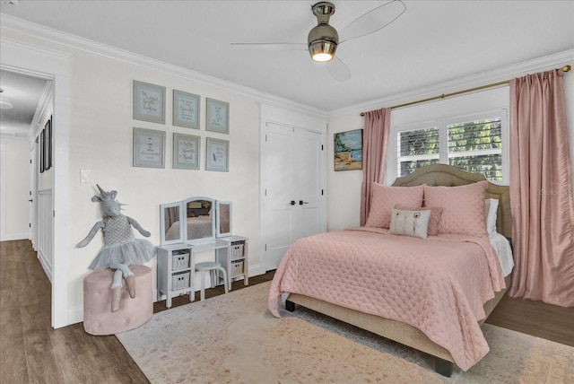 bedroom with ceiling fan, wood finished floors, a closet, and ornamental molding