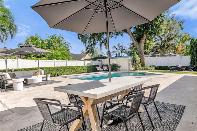 view of pool featuring a fenced in pool, outdoor dining area, an outdoor structure, a fenced backyard, and a patio