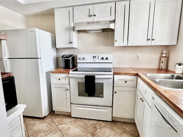 3672 Lake Bayshore Dr Unit K327, Bradenton, FL 34205 - kitchen with under cabinet range hood, a sink, light tile patterned flooring, white appliances, and butcher block countertops