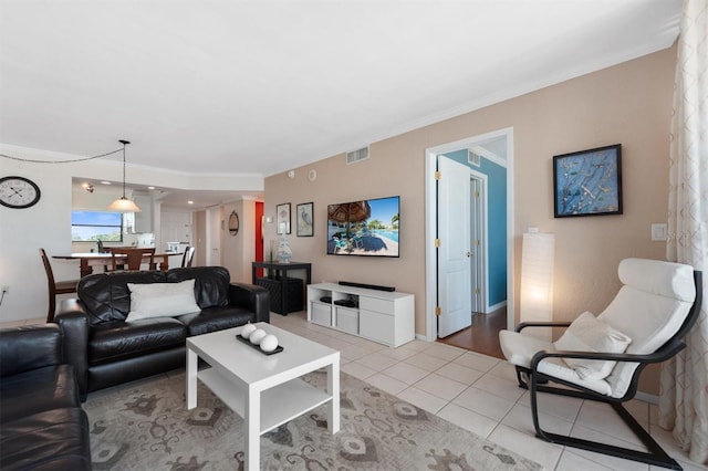 living area with light tile patterned floors, baseboards, visible vents, and ornamental molding