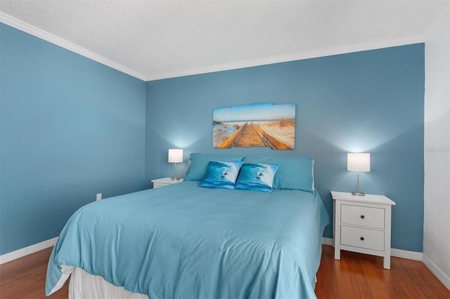 bedroom featuring crown molding, wood finished floors, and baseboards