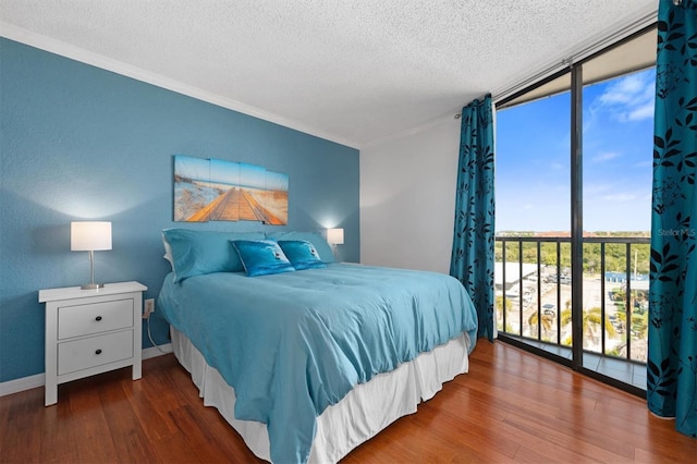 bedroom with floor to ceiling windows, ornamental molding, wood finished floors, and a textured ceiling