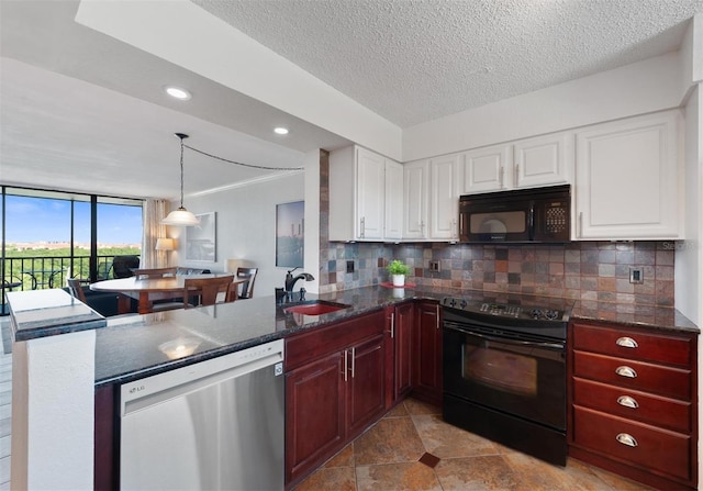 kitchen with decorative light fixtures, decorative backsplash, a peninsula, black appliances, and a sink