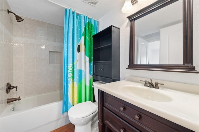 bathroom with vanity, visible vents, toilet, a textured wall, and shower / tub combo with curtain