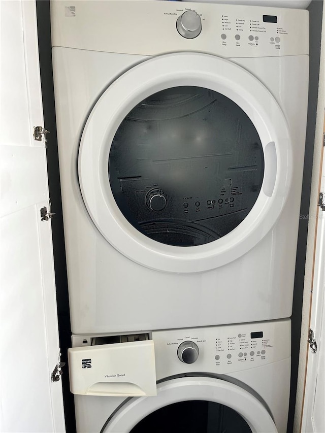 washroom featuring stacked washer / drying machine and laundry area