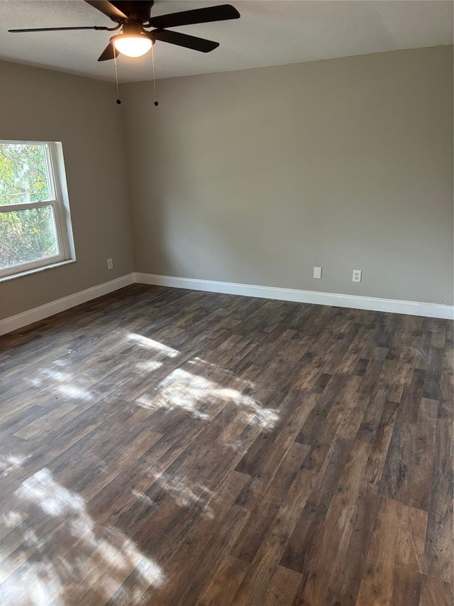 spare room with dark wood-style floors, ceiling fan, and baseboards