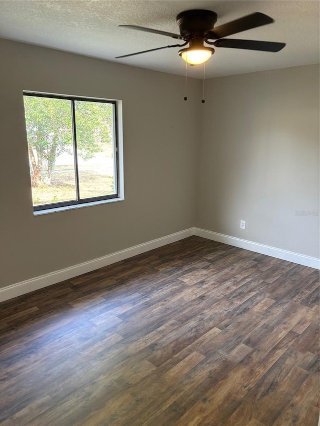 unfurnished room featuring a textured ceiling, baseboards, and dark wood-type flooring