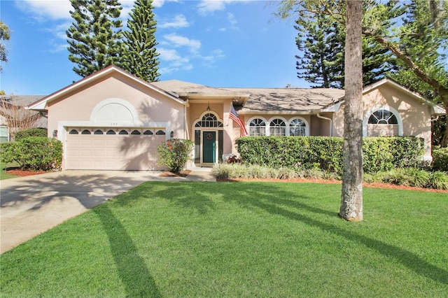 view of front of house with a front yard, concrete driveway, an attached garage, and stucco siding