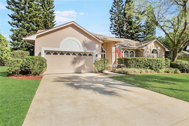 ranch-style house featuring a garage, concrete driveway, a front yard, and stucco siding