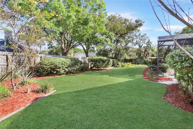 view of yard featuring glass enclosure and a fenced backyard