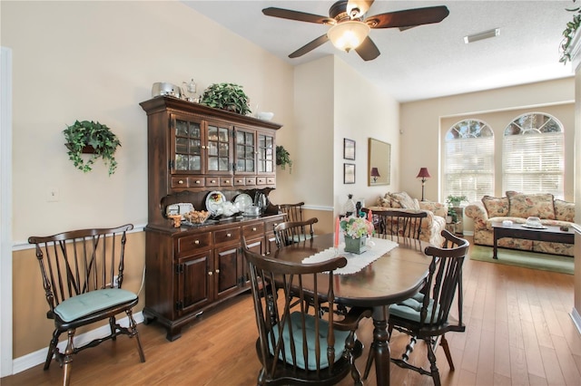 dining area with light wood-style flooring, visible vents, ceiling fan, and baseboards