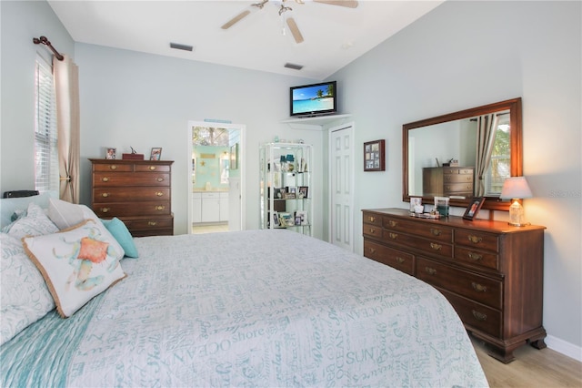 bedroom featuring light wood-style flooring, ensuite bath, visible vents, and a ceiling fan