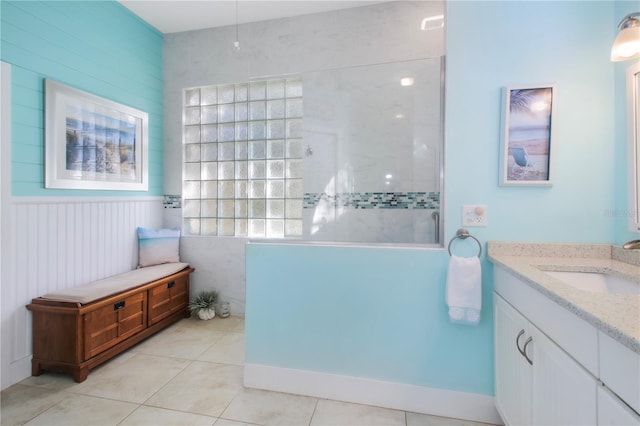 full bath with wainscoting, tile patterned flooring, a walk in shower, and vanity