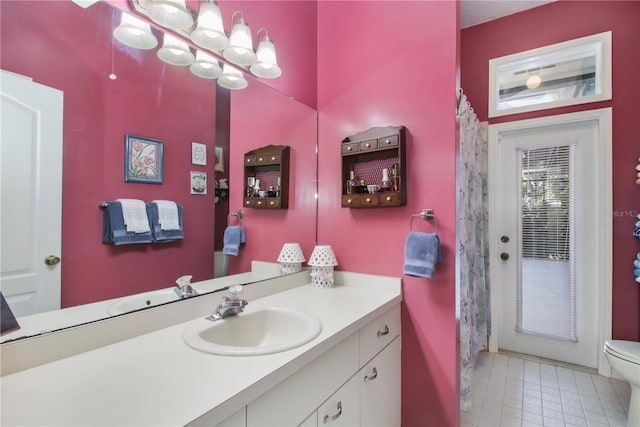 bathroom featuring toilet, a notable chandelier, and vanity