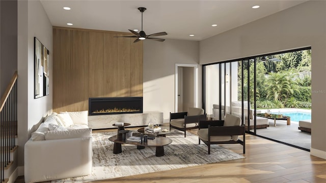 living room featuring recessed lighting, a large fireplace, and light wood-style flooring