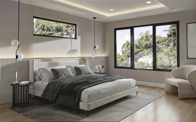 bedroom with a tray ceiling, recessed lighting, and wood finished floors