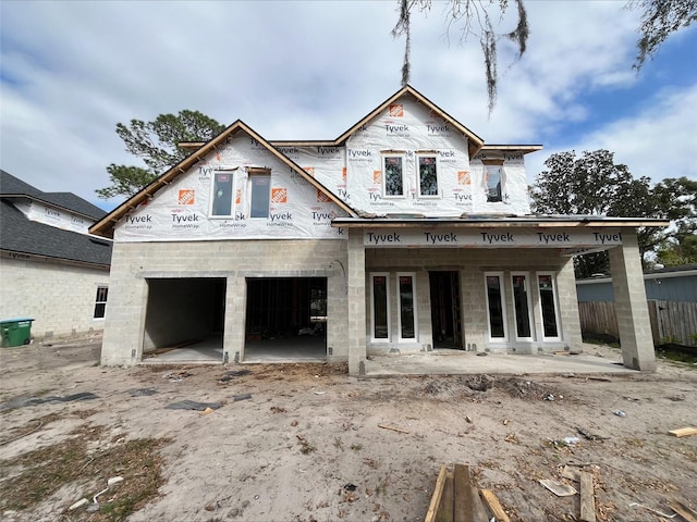 property in mid-construction with a garage and fence